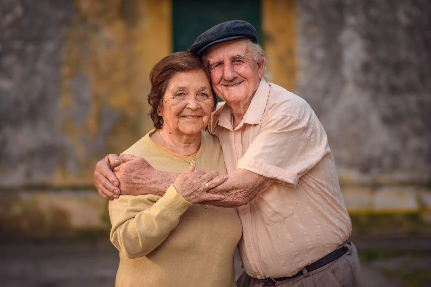 A smiling senior couple embracing outdoors, illustrating the health benefits of companionship after 60