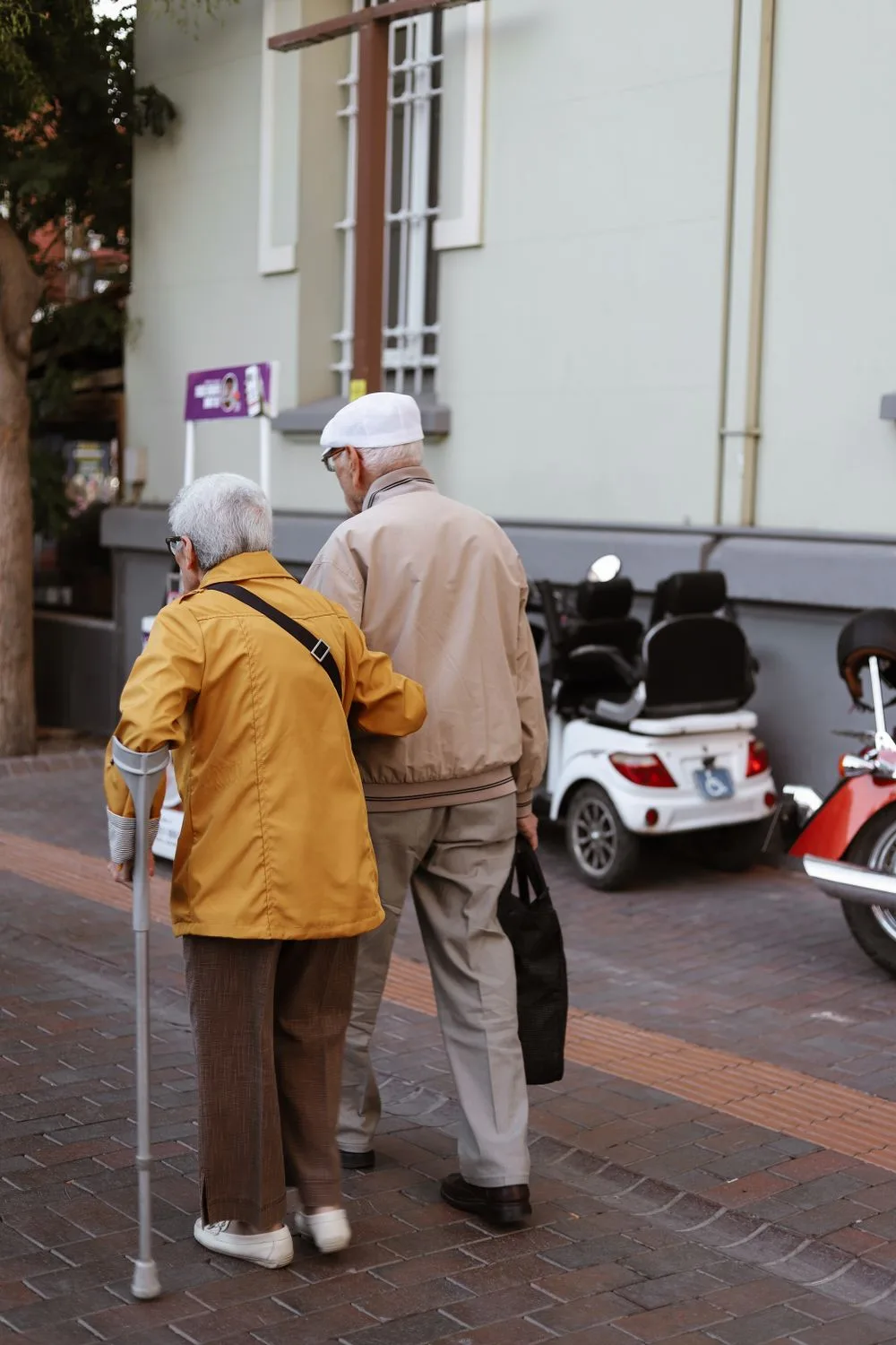 Two people over 50 walking arm in arm outdoors, illustrating a companionable first date